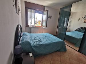 een slaapkamer met een bed en een raam bij Serenity Home in Posta Vecchia