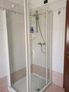 een douche met een glazen deur in de badkamer bij Serenity Home in Posta Vecchia