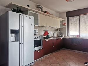 een keuken met een witte koelkast en rode kasten bij Serenity Home in Posta Vecchia