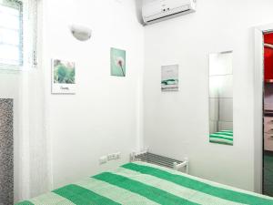 een witte kamer met een bed en een spiegel bij Casa Quarti in Rimini