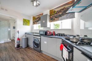 uma cozinha com máquina de lavar e secar roupa em *F1BR* for your most relaxed & Cosy stay + Free Parking + Free Fast WiFi em Batley