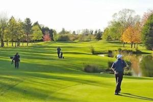 a group of people playing golf on a golf course at *F1BR* for your most relaxed & Cosy stay + Free Parking + Free Fast WiFi in Batley