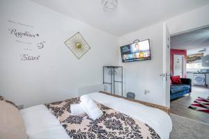 um quarto com uma cama e uma televisão na parede em *F1BR* for your most relaxed & Cosy stay + Free Parking + Free Fast WiFi em Batley