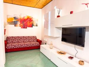 Casa Quarti في ريميني: غرفة معيشة مع أريكة وتلفزيون بشاشة مسطحة