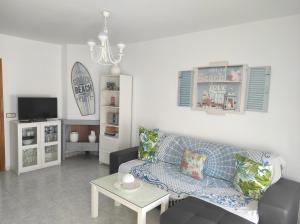 ein Wohnzimmer mit einem Sofa und einem Tisch in der Unterkunft islantilla adosado piscina parking 1 minuto al mar in Islantilla