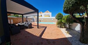 a patio with couches and a tree and a pool at VILLA DO LIMAO in Tavira