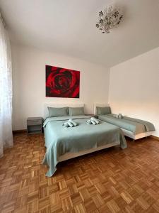 1 dormitorio con 2 camas y un cuadro en la pared en B&B al quadrifoglio posto auto, en Trieste