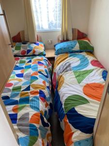 duas camas num pequeno quarto ao lado um do outro em Dunlin Dell at Thornwick Bay, Haven site em Flamborough