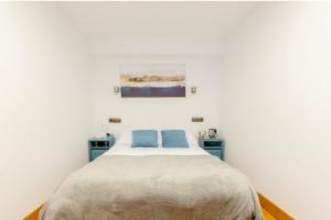 a bedroom with a large bed with two blue tables at Pensión San Vicente in San Sebastián