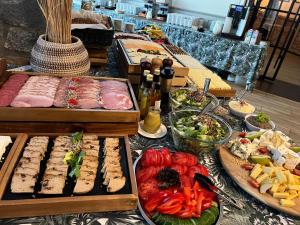 オルシュティネクにあるWiatraki Nature Resortのテーブルの上に様々な種類の料理を揃えたビュッフェ