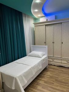 een slaapkamer met een wit bed en een blauw plafond bij ZahroSulton in Samarkand