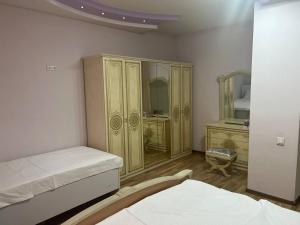 een slaapkamer met een bed en een dressoir bij ZahroSulton in Samarkand
