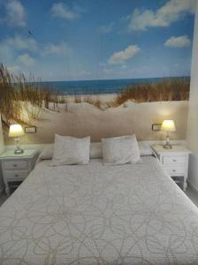 a bedroom with a bed with a view of the beach at islantilla adosado piscina parking 1 minuto al mar in Islantilla