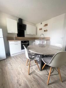 een keuken met een tafel en stoelen in een kamer bij Appartement avec piscine en Vallée d’Ossau in Bielle