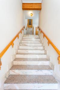 una escalera en una casa con paredes blancas y barandillas de madera en Casa Rural l'Olivera en Sant Mateu, cerca de Morella y Peñíscola - Casa Completa - Mínimo 2 noches, en Sant Mateu
