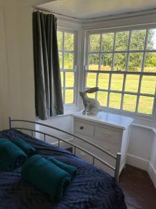 a bedroom with a bed and a dresser with a cat statue on it at Unique English Heritage Escape in *Bembridge* IOW in Bembridge