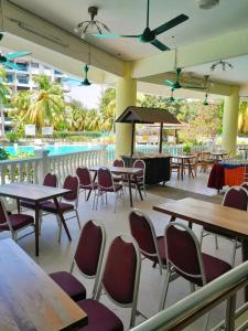 ein Restaurant mit Tischen und Stühlen und einem Pool in der Unterkunft Sunset view,Ground Floor to BEACH, 1-5pax in Port Dickson