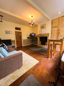 a living room with a couch and a fireplace at Rural Yorkshire Getaway - Modern Victorian Cottage, Long term stay offers, message direct in Luddenden Foot