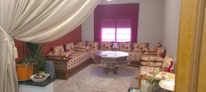 uma sala de estar com um sofá e uma mesa em Aziz agadir em Agadir