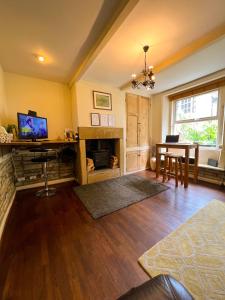 a living room with a table and a fireplace at Rural Yorkshire Getaway - Modern Victorian Cottage, Long term stay offers, message direct in Luddenden Foot