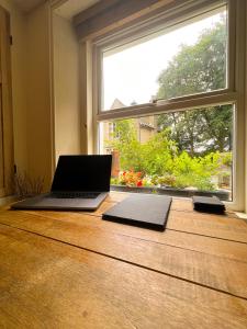 a laptop computer sitting on a table next to a window at Rural Yorkshire Getaway - Modern Victorian Cottage, Long term stay offers, message direct in Luddenden Foot