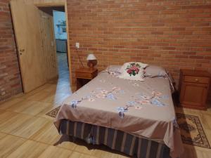 a bedroom with a bed and a brick wall at Casa de la Oma in Ruiz de Montoya