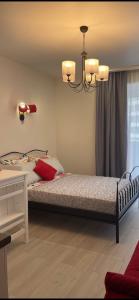sypialnia z łóżkiem i żyrandolem w obiekcie Apartment Batumi Weekend w mieście Batumi