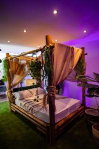 a bedroom with a bed with a canopy at L'Évasion Loveroom in Sarreguemines