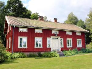 een rood huis met een witte deur bij Dalen in Hökerum