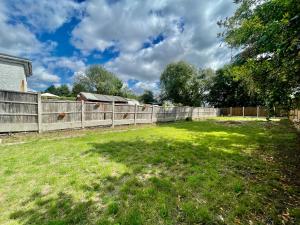 a backyard with a fence and a grass yard at Modern 4 Bed Romford Home - Free Parking in Great Warley Street