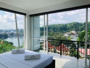 a bedroom with a bed and a large window at The Glen Kandy in Kandy