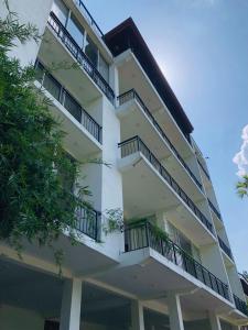a tall white building with balconies on it at The Glen Kandy in Kandy