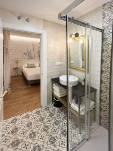 uma casa de banho com um chuveiro, um lavatório e uma cama em Cervantes 5 Collection - Greco Aparcamiento en el Edificio em Toledo