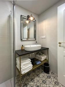 uma casa de banho com um lavatório e um espelho em Cervantes 5 Collection - Greco Aparcamiento en el Edificio em Toledo