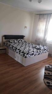 a bedroom with a bed with a black and white comforter at Casa Loredana in Mangalia