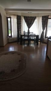 a dining room with a table and chairs and a rug at Casa Loredana in Mangalia