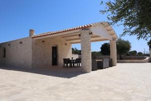 an outdoor pavilion with a table and chairs at Dimora Sasa in Putignano