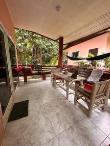a patio with two chairs and a table and a hammock at Cozy Garden House in Kohphangan! in Ban Nua