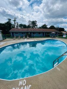 una grande piscina blu senza insegna di nuoto di fronte a un edificio di Captain's Lodge Motel a Gloucester