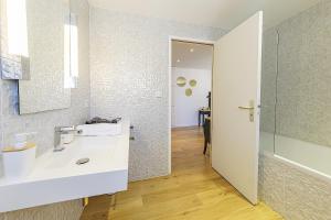 a bathroom with a white sink and a mirror at Maison Bossoreil - Chambre Layon in Angers