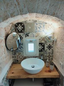 a bathroom with a sink and a computer on a counter at Dimora Storica Il Tiglio in Castellana Grotte