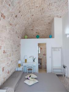 um quarto com uma cama e uma parede de tijolos em Dimora Storica Il Tiglio em Castellana Grotte