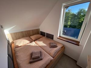 a small bedroom with a bed and a window at Hotel U Kociana in Trojanovice