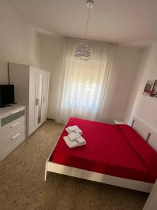 sypialnia z czerwonym łóżkiem i ręcznikami w obiekcie Manubella Appartamento 5 vani con giardino w mieście La Spezia