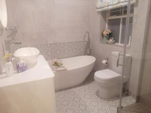 uma casa de banho com uma banheira, um WC e um lavatório. em Hermanus Sea view room em Hermanus
