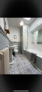 a bathroom with a tub and a toilet and a sink at Rural Yorkshire Getaway - Modern Victorian Cottage, Long term stay offers, message direct in Luddenden Foot