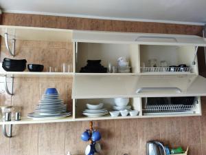 un armario de cocina con platos y platos. en Itaja Apartment 91, en Šiauliai
