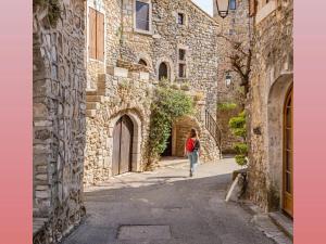 a woman walking down a street in an alley at La Poussinière in Aiguèze