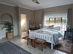 a bedroom with a white bed and a large window at Elvandar Country Cottage in Hilton