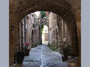 an alley with an archway in a stone building at La Poussinière in Aiguèze +17 photos